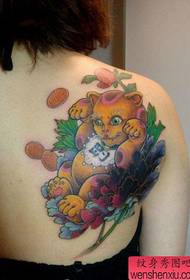 На гърба на момичето хубаво изглеждащ цветен модел татуировка на късмет
