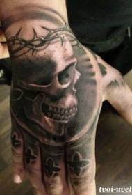 Patrón de tatuaxe de cinzas e espiñas negras na parte traseira da man