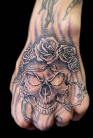 Rāpojošs melno pelnu un rožu vīnogulāju tetovējuma raksts rokas aizmugurē