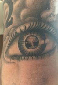 Očné tetovanie, mužská ruka, tetovanie očí