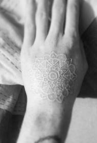Krásny biely neviditeľný vanilkový tetovací vzor na zadnej strane ruky