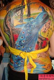 Een mooi ogende vrouw met een kleurrijk pauw tattoo-patroon