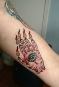 Niño pintando el brazo en imagen de tatuaje de mano y ojo de llama degradada