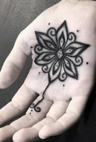 Modello creativo nero piccolo tatuaggio nel palmo della mano