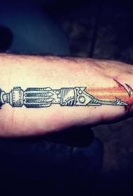 Foto de tatuatge d'espasa de colors clars a mà de l'escola