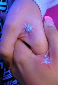 Paartjiehand hou van klein fluoresserende tatoeëringpatroon van getuienis