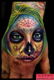 uma tatuagem colorida menina morte na parte de trás da mão