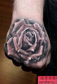 Uma popular tatuagem clássica de rosa em preto e branco na parte de trás da mão