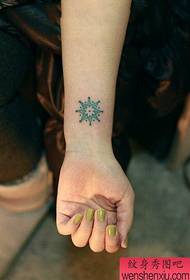 Pergelangan tangan perempuan memiliki pola tato totem yang sangat kecil