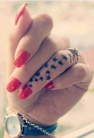 Mergaitė laižo pirštą šviežio žvaigždės tatuiruotės modelio paveikslėlyje