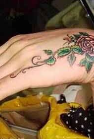 Dora e vajzës mbrapa bukur modelin e bukur të luleve të tatuazheve të luleve