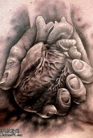 Patrón de tatuaje de corazón en mano
