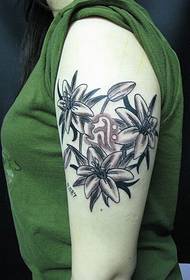 Piękny, pięknie wyglądający obraz tatuażu z kwiatami na ramieniu pięknej dziewczyny
