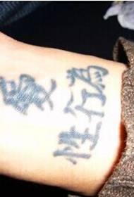 A manu di u zitellu fa una foto sorridente di tatuaggi di testu