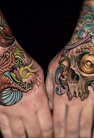 un tatuaj de șarpe în stil școlar pe spatele mâinii