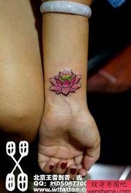 Poignets de filles, petits et délicats motifs de tatouage lotus rose