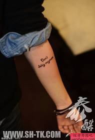 Mujer brazo un patrón de tatuaje de palabra en inglés
