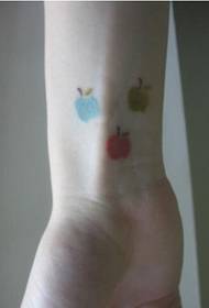 Gambar gambar tatu epal yang cantik dan cantik di pergelangan tangan gadis itu