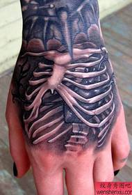 un tatuaggio scheletro personalizzato sul dorso della mano
