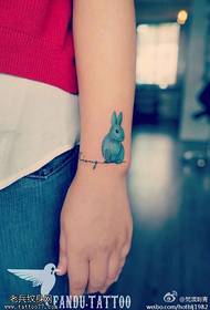 Padrão de tatuagem de coelho de desenho animado mão feminina