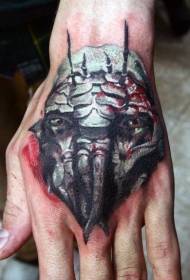 Patró de tatuatge de la cara de monstre amb un disseny únic a la part posterior de la mà