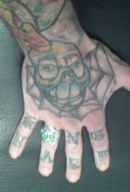 Na hrbtni strani roke je vzorec tatoo z zobastim obrazom
