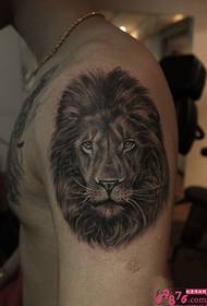 Dominante leeuwenkop grote arm tattoo foto