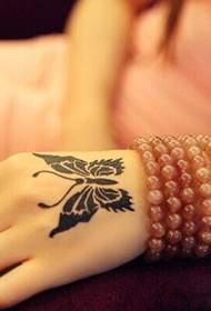 Skaista meitenes roka skaista melnbalta tauriņa tetovējuma attēla bilde