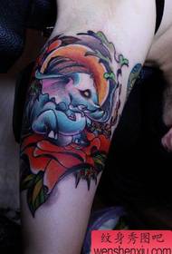 La mano stampa un piccolo disegno del tatuaggio dell'elefante nei fiori