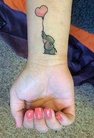 Linda foto de tatuaje de malgranda elefanto kaj ruĝa koro-globo sur pojno de knabino