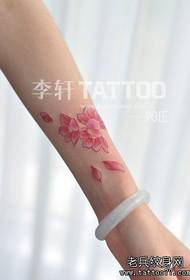 Maliit ang braso ng batang babae at sikat na pattern ng tattoo ng cherry blossom