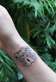 Gambar tato kupu putih ireng lan putih sing katon tangan