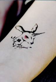 Tangan wanita nganggo gambar tato kancil sing apik lan apik