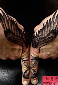 Arm met een zwart grijs vleugels tattoo-patroon