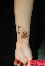 Girl's little arm, a small crown tattoo pattern