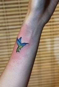 Mergaitės vaiko rankos gražus kolibrio tatuiruotės modelis