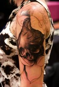 Na ramenu smeđi akvarelni oblik tetovaže lubanje