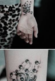 Coróin láimhe chailín agus patrún tattoo slabhra