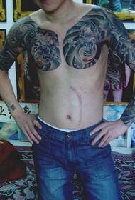 Ευρωπαϊκή και αμερικανική άνδρες όμορφος μισό-ένα τοτέμ λουλούδι τατουάζ βραχίονα