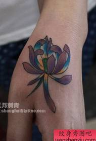 Braccio da ragazza, un piccolo disegno colorato del tatuaggio del loto