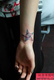 Meitenes plaukstas locītava ar piecstaru zvaigzni un zvaigžņotu tetovējuma rakstu