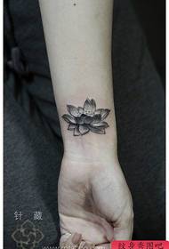 여자의 손목에 아름다운 검은 색과 흰색 연꽃 문신 패턴