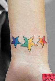 Dziewczyna nadgarstek mały kolorowy pięcioramienny wzór tatuażu gwiazdy