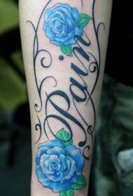 Ramię z kolorowym wzorem tatuażu z różą i literą