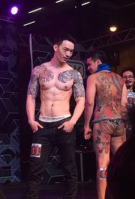 Ang gamay nga lab-as nga karne sa tindog nagpakita sa iyang gwapo nga doble nga tunga nga tattoo