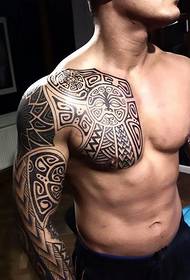 Foto de tatuaje de tótem de mitad de tribu de mano derecha de chico guapo