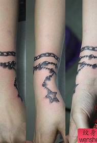 Bellissimo tatuaggio con braccialetto a stella a cinque punte sul polso della ragazza