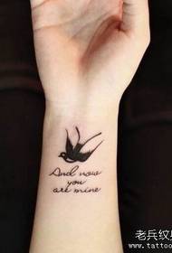 Polso da bambina con piccole rondini e motivo tatuaggio a lettere