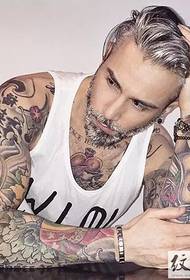 Guardando il grande uomo mostrare un grande tatuaggio di moda
