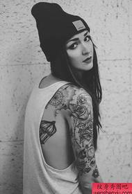 タトゥーショーの写真は、女性の黒と白の花の腕のタトゥーパターンをお勧めします